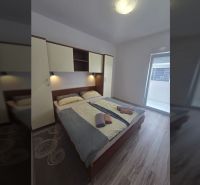 Bedroom with a double bed and a wooden decor floor in a 2-room apartment.