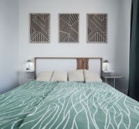 Bedroom in a 2-room apartment with patterned bedding and geometric decorations.