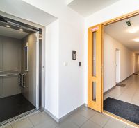 A hallway with an elevator in a 2-room apartment, neutral decor and clean lines.