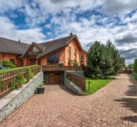 A family house in Veľká Lomnica with a well-maintained garden and a paved driveway.