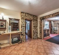 A hallway with a fireplace in a family house, where there is space for storing wood.