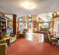Interior of a family house with a library, comfortable armchairs, and a wooden decor floor.