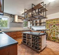 A kitchen in a family house with a ceramic floor and a colorful curtain.