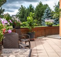 The exterior of a family house in Veľká Lomnica with a terrace surrounded by flowers and plants.