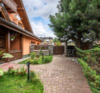 A family house in Veľká Lomnica with a colorful garden and a paved walkway.