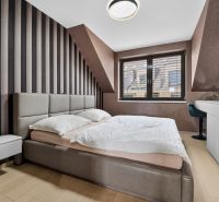 A bedroom in a 3-room apartment with a wood-patterned floor and striped wallpaper.