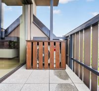 The balcony of a 3-room apartment on Halenárska Street in Trnava with a wooden fence and tiles.