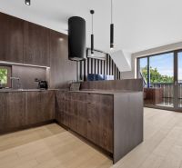 A kitchen with dark cabinets and a wood-patterned floor in a 3-room apartment.