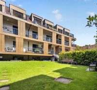 Apartment building with loggias on Halenárska Street in Trnava, surrounded by a grassy garden.