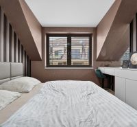 A bedroom in a three-room apartment with striped wallpaper and a skylight.