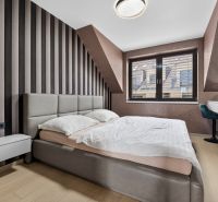 A bedroom in a 3-room apartment with an upholstered bed and a floor with a wood decor.