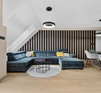 Bright living room with a sofa, dining table, and wood-patterned flooring in a 3-room apartment.