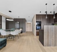 Interior of a 3-room apartment with a wooden decor floor, dining table, and kitchen.