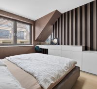 A bedroom with wood-patterned flooring, white furniture, and a striped wall in a 3-room apartment.