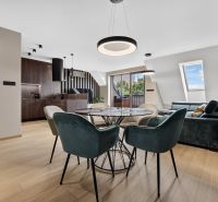 A dining room with a wood-patterned floor in a 3-room apartment, elegant interior with a round table.