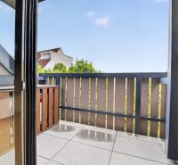 The balcony of a 3-room apartment on Halenárska Street in Trnava with a wooden railing.