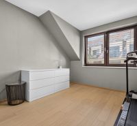 A bright room with a wood-patterned floor, a weight bench, and a dresser in a 3-room apartment.