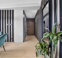 A hallway in a 3-room apartment with striped walls and a wooden decor floor.
