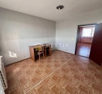 A room with a wooden floor decor, a desk, and a chair in a three-room apartment.