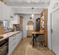 A kitchen in a family house with a wooden decor floor and a dining table.