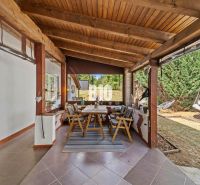 Covered terrace of a family house in Podhájska with a dining table and a hammock.