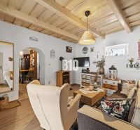 Interior of a family house with a wooden decor floor, furniture, and a ceiling-mounted fireplace.