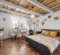 A family house with a wooden decor floor, a double bed, and a dining area.