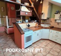 A kitchen in a family house with a countertop, ceramic floor, and dining area.