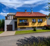 Yellow family house in Podolínec with a red roof and a garden.