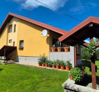 A family house in Podolínec with a garden, grassy plot, and wooden gazebo structure.