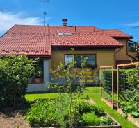 A family house in Podolínec with a red roof, a garden, and fruit trees.