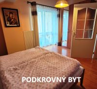 A bedroom in a family house with a wooden decor floor and balcony doors.