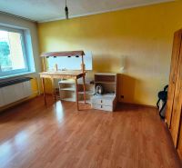 A room with a wooden floor decor, yellow walls, and furniture in a family house.