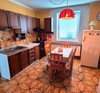 Rustic kitchen in a family house with floral wall tiles and flooring.
