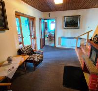 Living room with a fireplace, warm interior, wooden ceiling, family house in Podolínec.