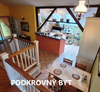 Attic apartment with a dining table, kitchen, and staircase, floor with wood decor.