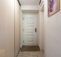 A hallway in a one-room apartment with a wooden decor floor and a built-in wardrobe.