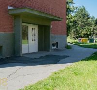 Exterior of a building with a lawn and a walkway in Poprad, near a 1-room apartment.