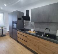 A kitchen in a 3-room apartment with a wooden decor floor and stylish seating.
