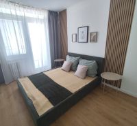 A bedroom in a 3-room apartment with a bed and a floor with a wooden decor.