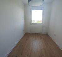 A room with a wooden decor floor and a window in a 3-room apartment.