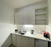 Office kitchen equipment with cabinets, sink, electric kettle, and dishwasher.