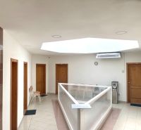 Hallway in the office with doors, skylight, chairs, and a water dispenser.