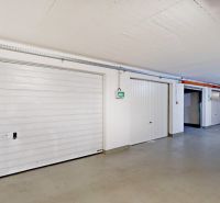 The white garage doors on Šustekova Street in Bratislava - Petržalka are closed.