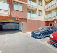 Garages on Šustekova Street in Bratislava-Petržalka with parked cars in front of the entrance.