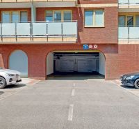 Garages on Šustekova Street in Bratislava-Petržalka with cars parked in front of the entrance.
