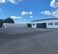Warehouses and halls in Ličartovce with a spacious outdoor area and a blue sky.