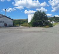 Warehouses and halls in Ličartovce with an asphalt road and greenery in the surroundings.