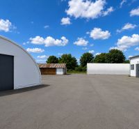 Warehouses and halls in Ličartovce with open space and blue sky.