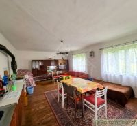 Dining room in a family house with a wooden decor floor and wooden furniture.